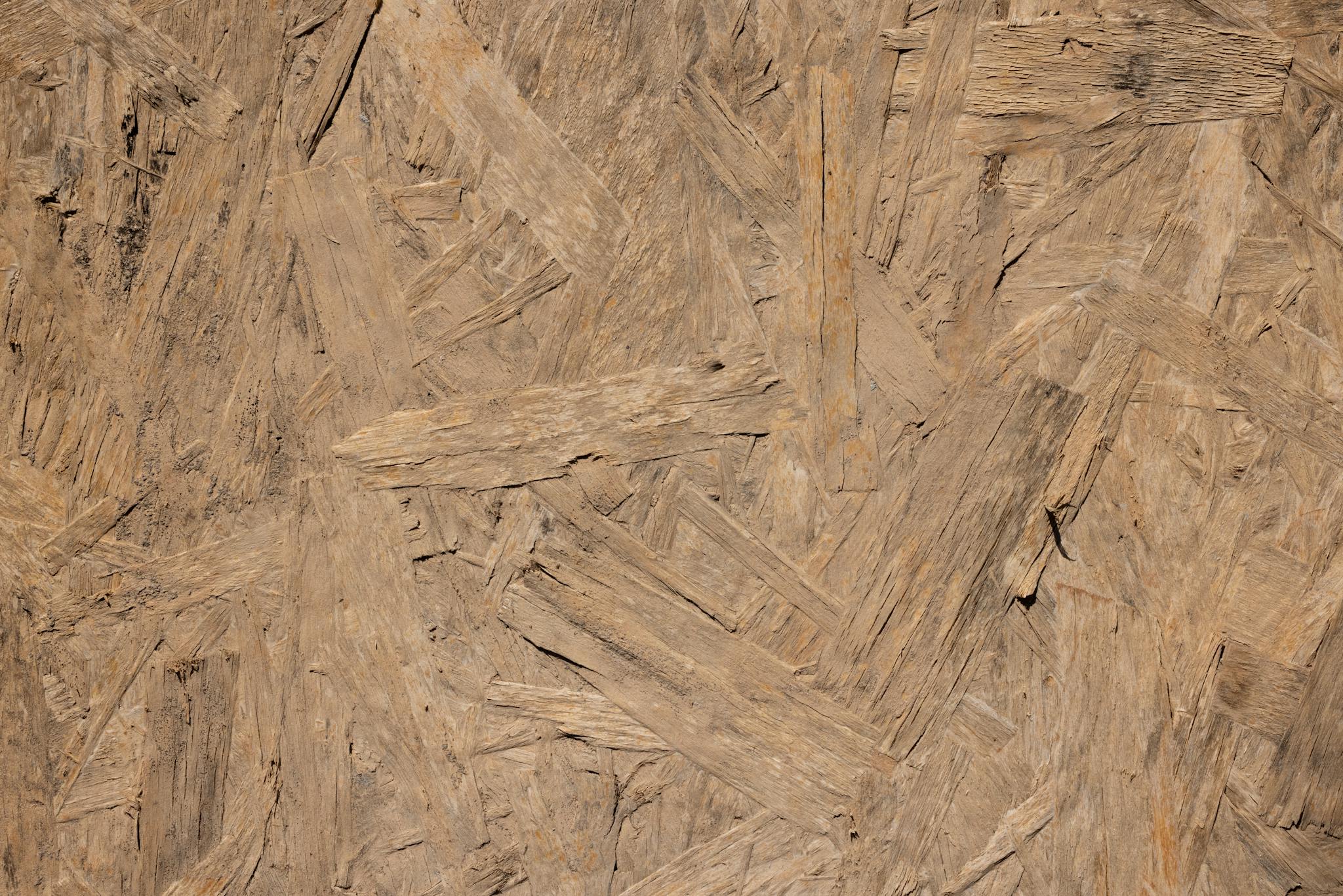 Close-up of a rough textured oriented strand board (OSB) wooden surface.